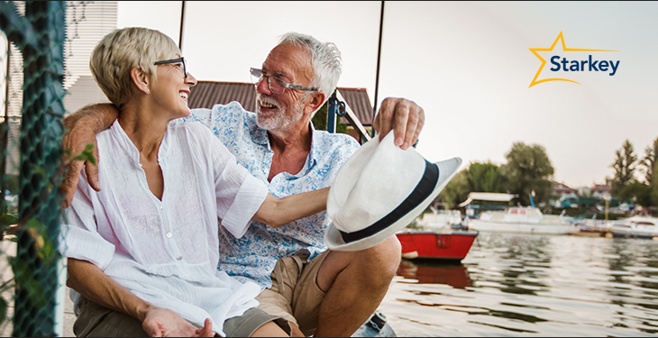 Image of a happy senior couple sitting together on a dock 
